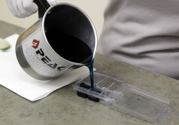 Pouring wax into tart mold.